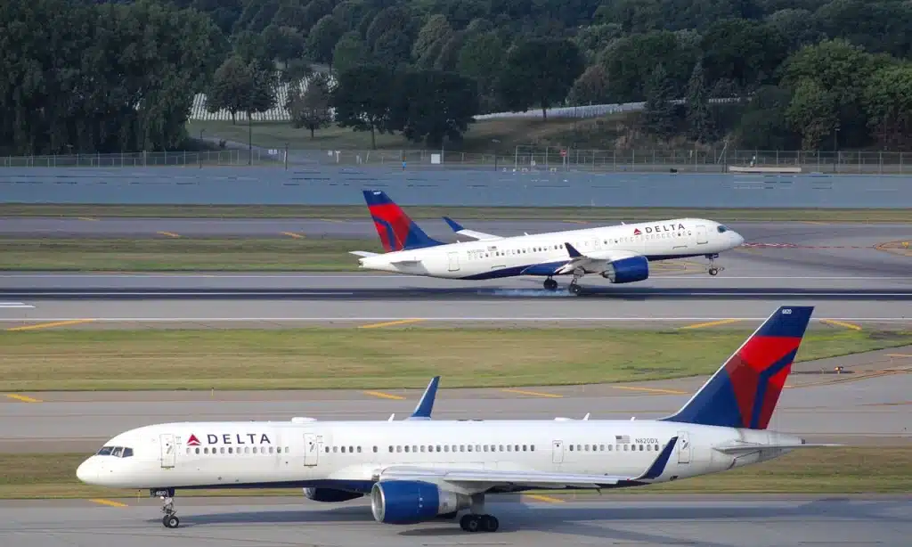 Delta Air Lines Airbus A220 taking off in the background.