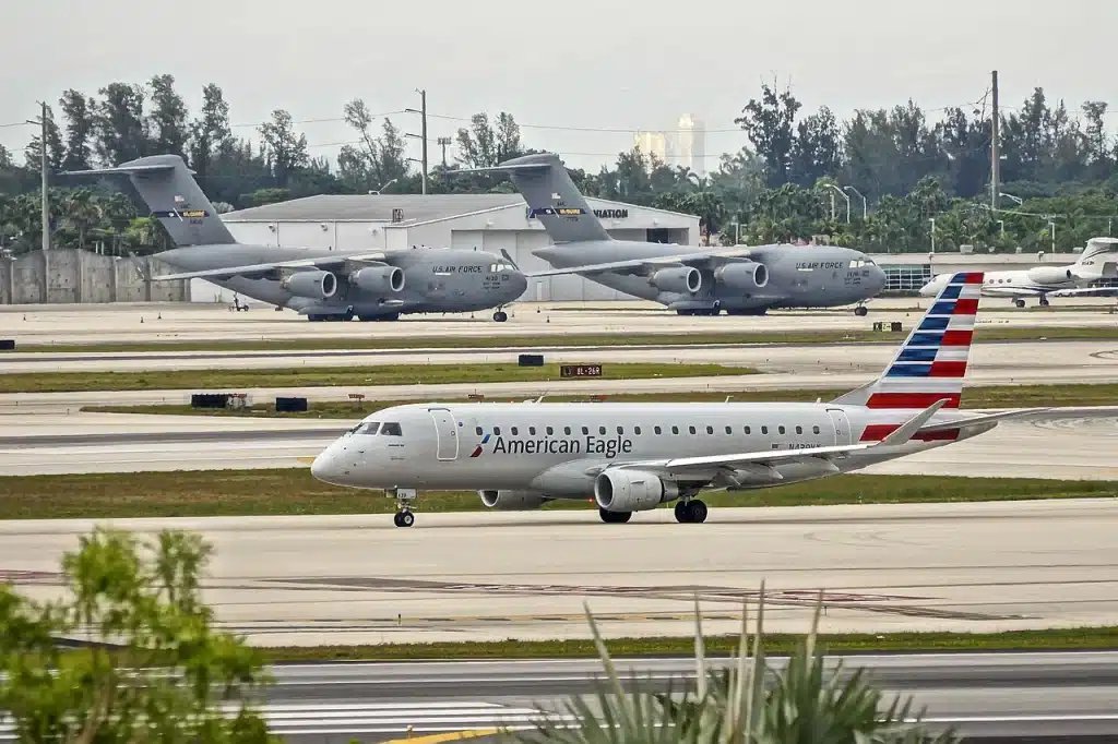 American Eagle Embraer 175 taxiing at Miami with C-17's in the background.