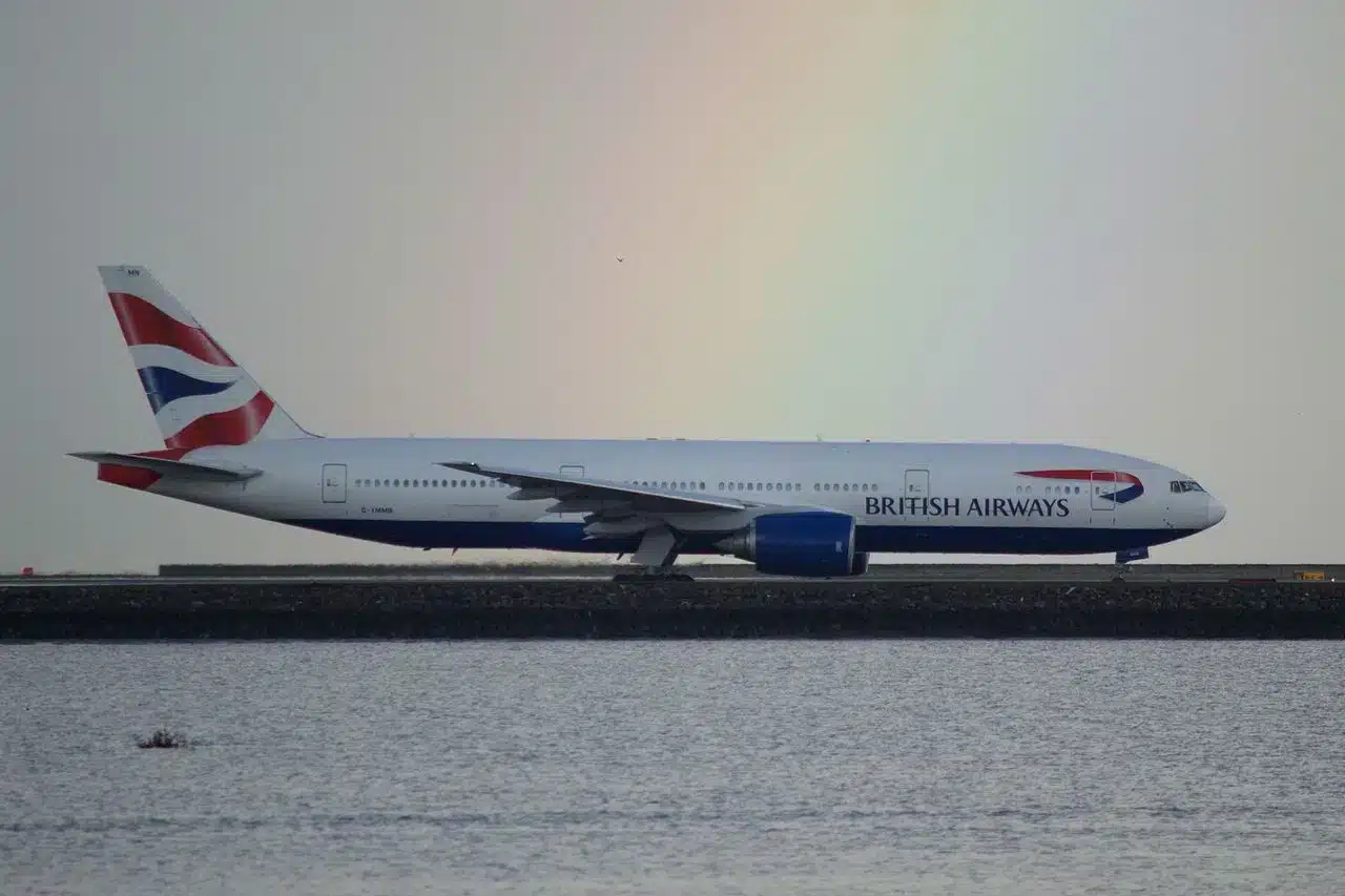 British Airways Boeing 777 taxiing with a rainbow in the background.