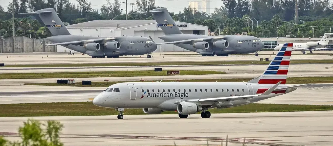 American Eagle Embraer 175 taxiing at Miami with C-17's in the background.